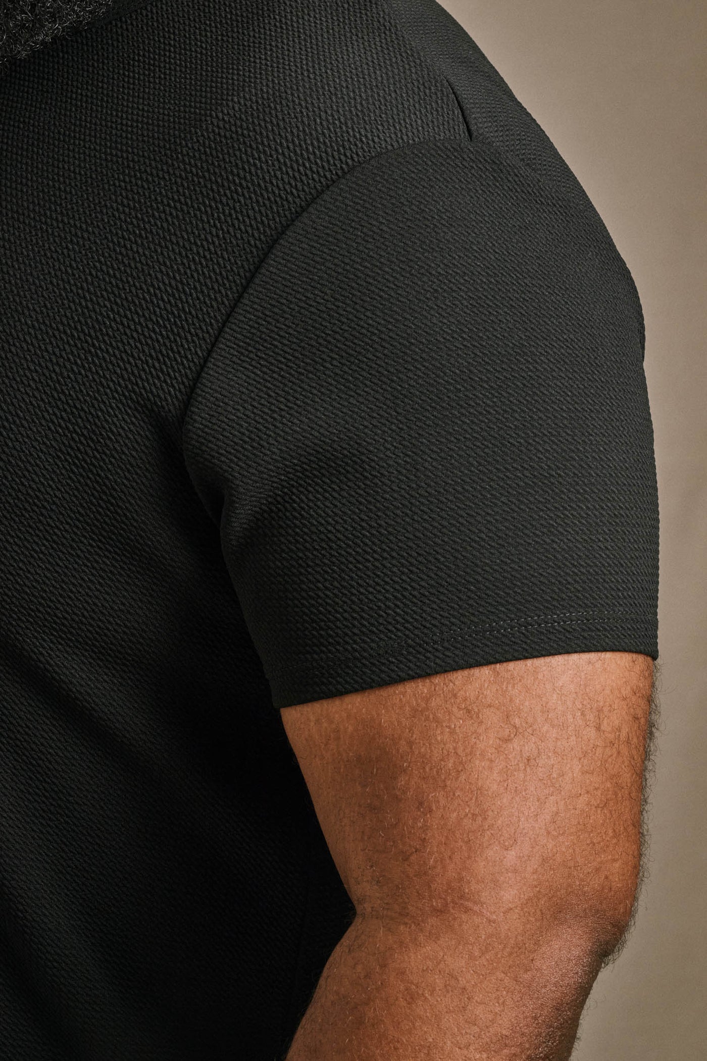Close-up of the sleeve construction and textured piqué fabric of the ONE BONE Bullet Tee