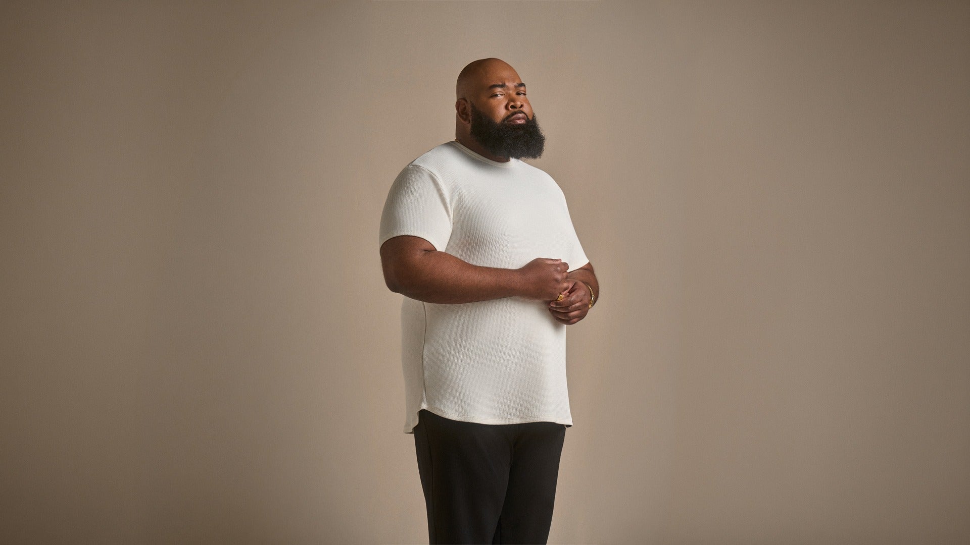 Man wearing a cream tee and dark pants